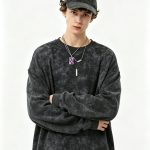 Acid-wash black crewneck sweatshirt worn by a model