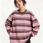 Blush striped knit sweater worn by a model