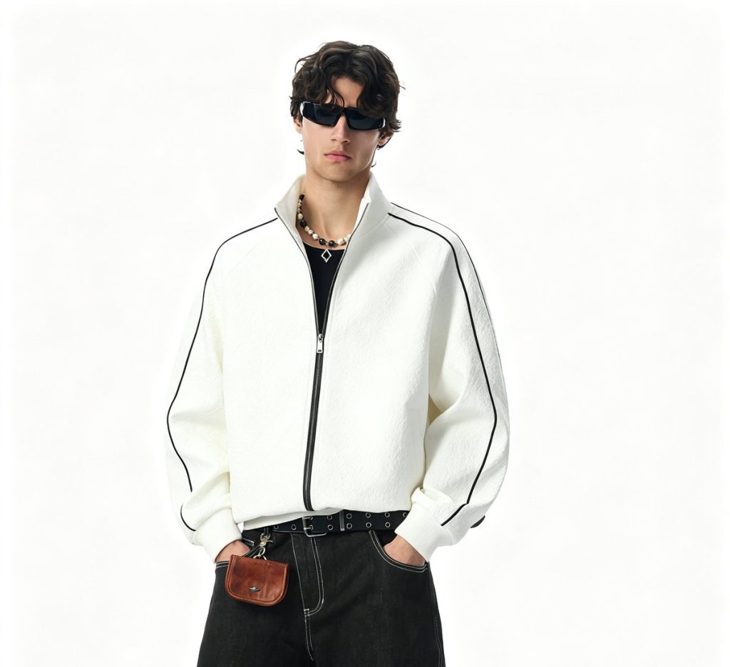 Bone full-zip track jacket with black piping, worn by a model