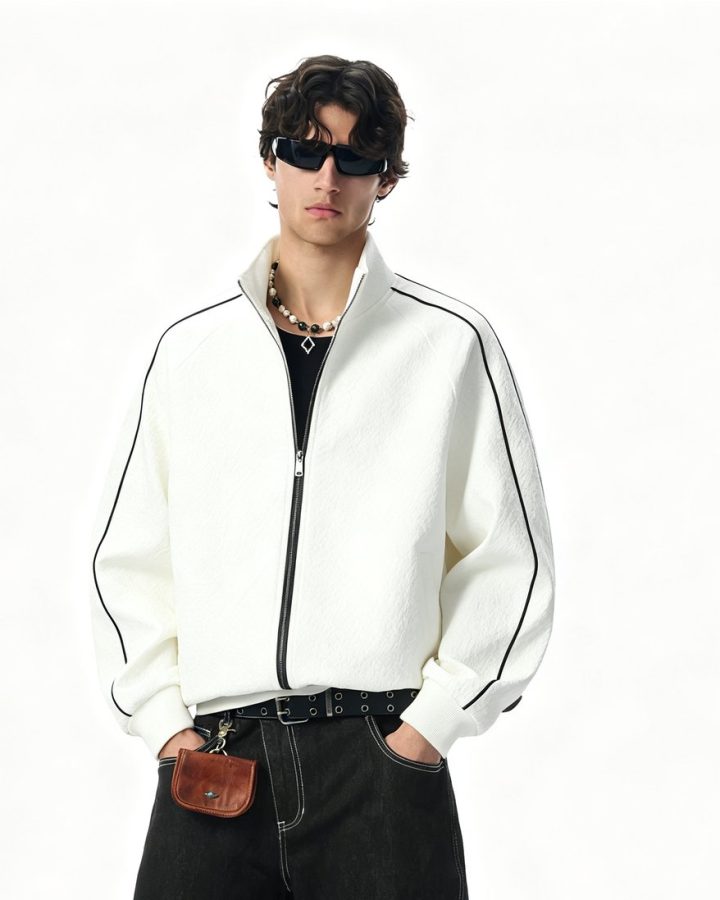 Bone full-zip track jacket with black piping, worn by a model