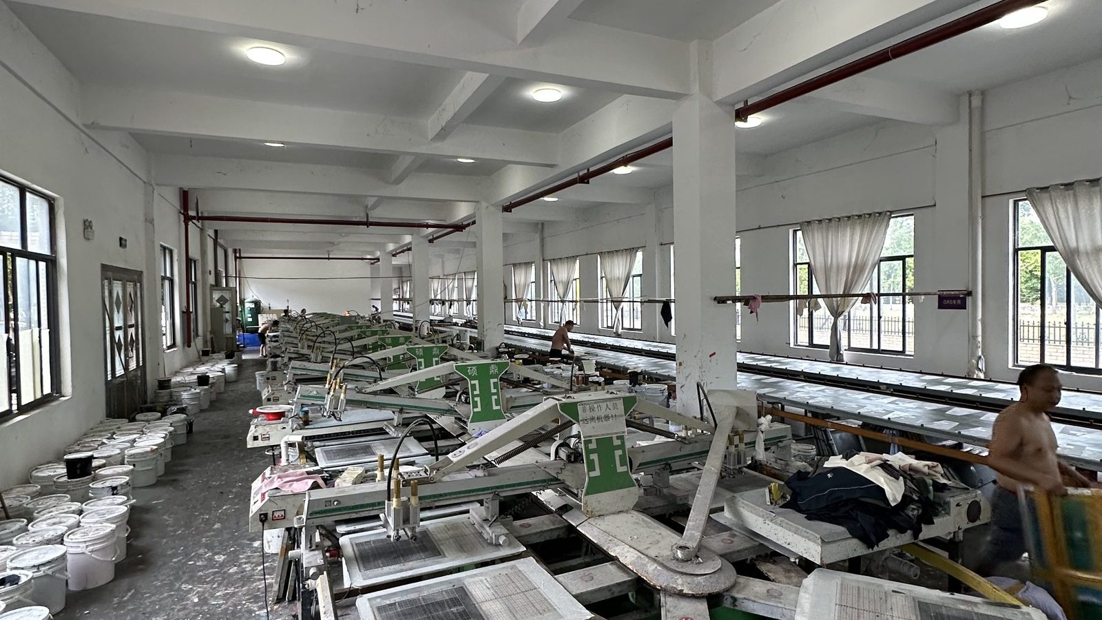Rotary screen printing carousel with printing stations and ink buckets