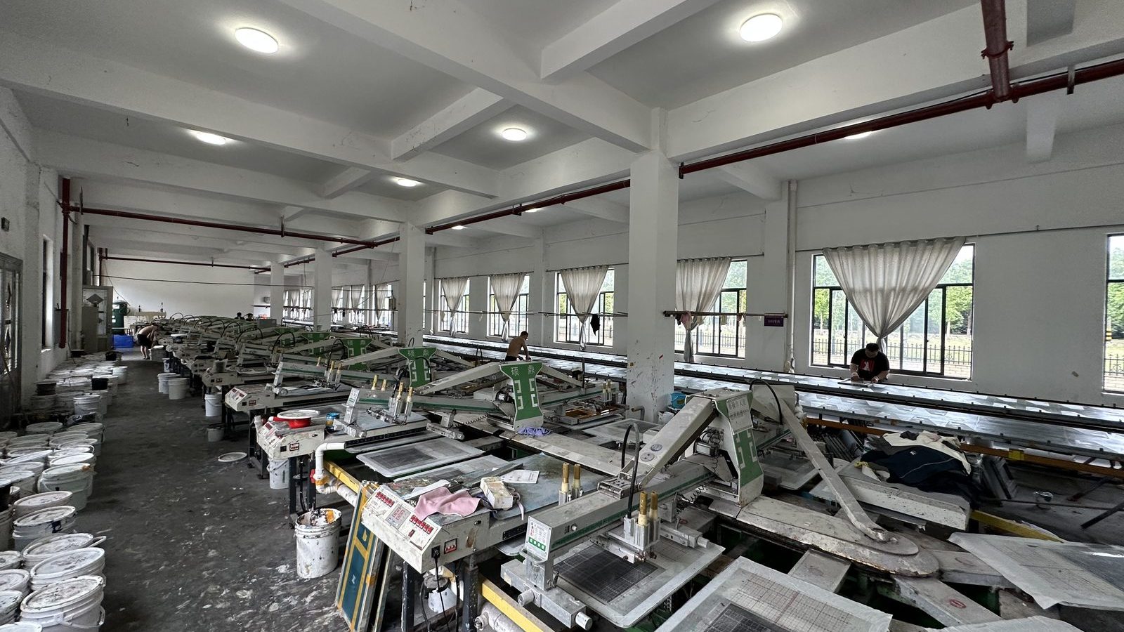 Row of screen printing stations along the printing hall