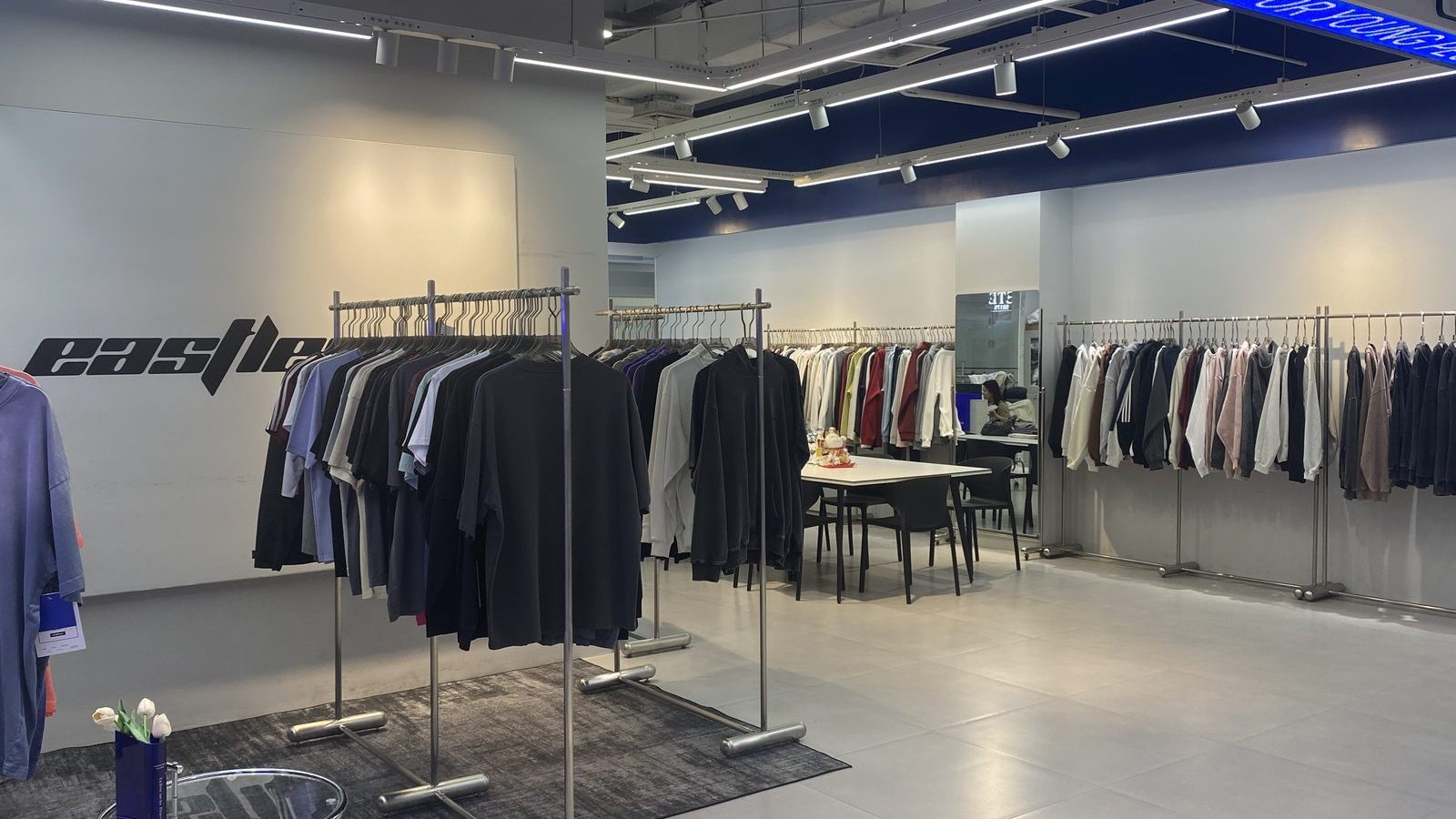 Garment rails in the EASTLEVEL showroom with jackets and knitwear on display