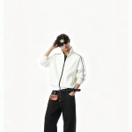 Bone zip-through hoodie worn with black trousers, full length view